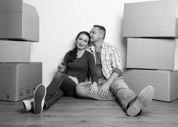 Ευτυχισμένο ζευγάρι στο νέο σπίτι τους με τα κουτιά από χαρτόνι — Φωτογραφία Αρχείου