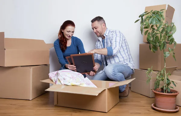 Happy couple unpacking boxes — Stock Photo, Image