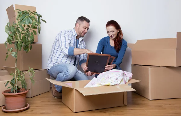 Happy couple unpacking boxes — Stock Photo, Image