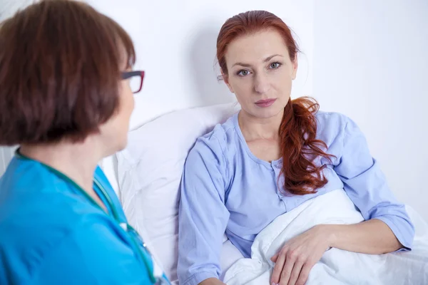 Paciente do sexo feminino deitada no leito hospitalar — Fotografia de Stock