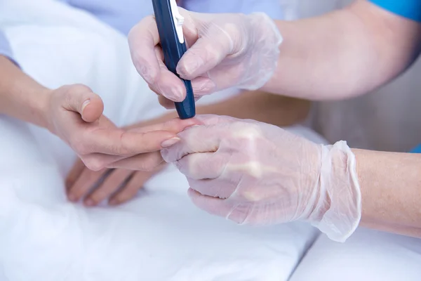 Vrouwelijke patiënt liggend in ziekenhuisbed en talking to verpleegkundige — Stockfoto