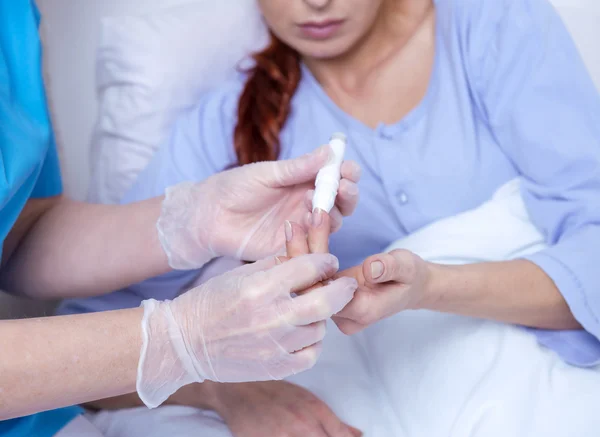 Vrouwelijke patiënt liggend in ziekenhuisbed en talking to verpleegkundige — Stockfoto