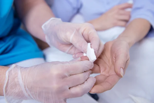 Vrouwelijke patiënt liggend in ziekenhuisbed en talking to verpleegkundige — Stockfoto