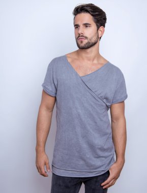 Yakışıklı genç adam günlük kıyafetlerle poz veriyor.