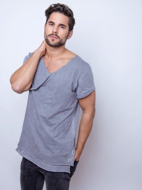 Yakışıklı genç adam günlük kıyafetlerle poz veriyor.