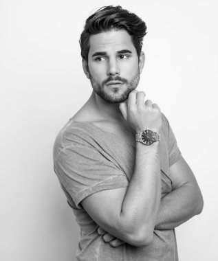 Yakışıklı genç adam günlük kıyafetlerle poz veriyor.