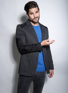 Yakışıklı genç adam günlük kıyafetlerle poz veriyor.