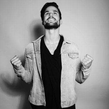 Yakışıklı genç adam günlük kıyafetlerle poz veriyor.