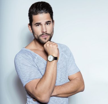 Yakışıklı genç adam günlük kıyafetlerle poz veriyor.