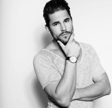 Yakışıklı genç adam günlük kıyafetlerle poz veriyor.