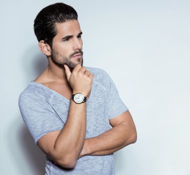 Yakışıklı genç adam günlük kıyafetlerle poz veriyor.