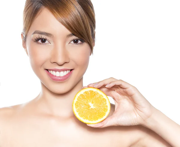 Bela jovem mulher asiática com cabelos longos, pele impecável e maquiagem perfeita, segurando laranja — Fotografia de Stock