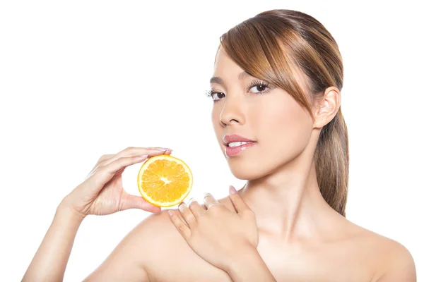 Beautiful young asian woman with long hair, flawless skin and perfect make-up, holding orange — Stock Photo, Image