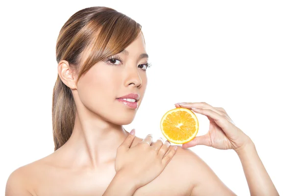Bela jovem mulher asiática com cabelos longos, pele impecável e maquiagem perfeita, segurando laranja — Fotografia de Stock