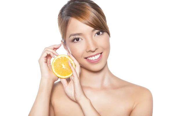 Beautiful young asian woman with long hair, flawless skin and perfect make-up, holding orange — Stock Photo, Image