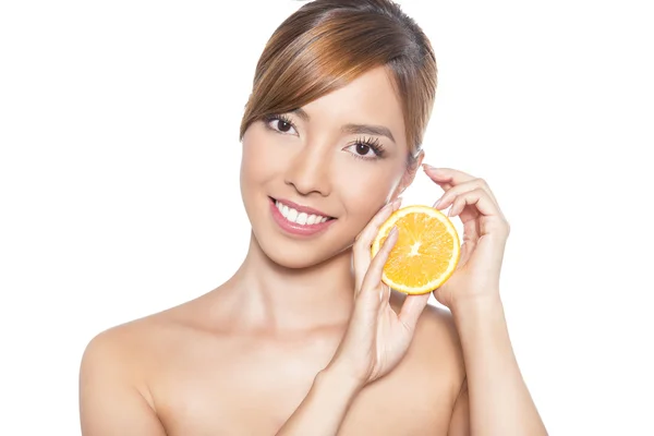 Beautiful young asian woman with long hair, flawless skin and perfect make-up, holding orange — Stock Photo, Image