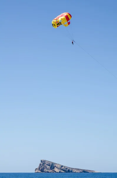 Αλεξίπτωτο που πετούν πάνω από το νησί ορόσημο — Φωτογραφία Αρχείου