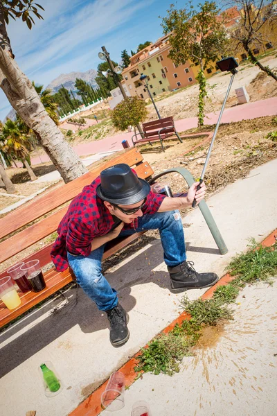 Guy throwing up on a park bench — Stock Photo, Image