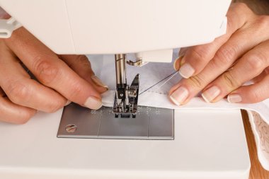 Eller, bir dikiş makinesi