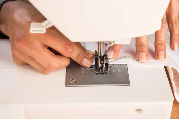 在一台缝纫机的女性手 — 图库照片