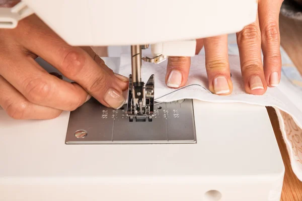 Mains féminines à une machine à coudre — Photo