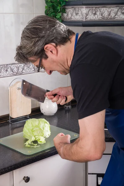 Парень пытается нарезать салат. — стоковое фото