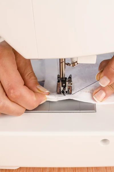 Vrouwelijke handen op een naaimachine — Stockfoto