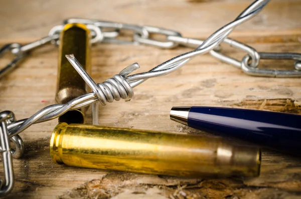 Bullets, pen and barbed wire — Stock Photo, Image