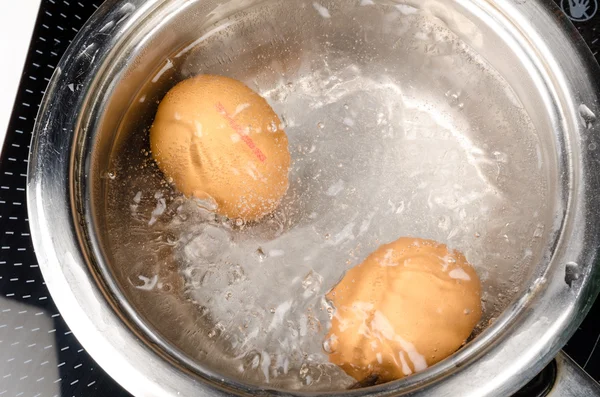 Eggs boiling in pan — Stock Photo, Image