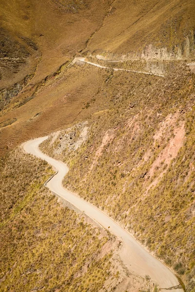 Camino andino de tierra serpenteando en lo alto — Foto de Stock