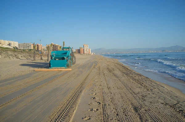 Trator limpando uma praia — Fotografia de Stock