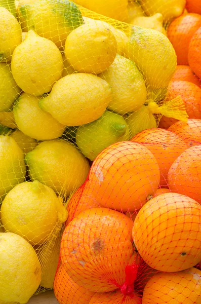 Oranges and lemons in nets — Stock Photo, Image