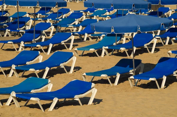 Parasols en ligstoelen op het strand — Stockfoto