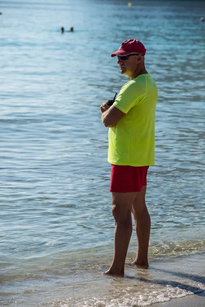 Livräddare stående på stranden — Stockfoto