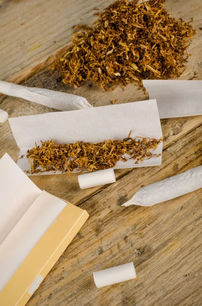 Walcówka papierosów na drewnianym stole — Zdjęcie stockowe