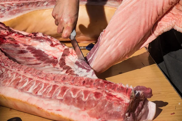 Mani da macellaio su carne di maiale fresca — Foto Stock