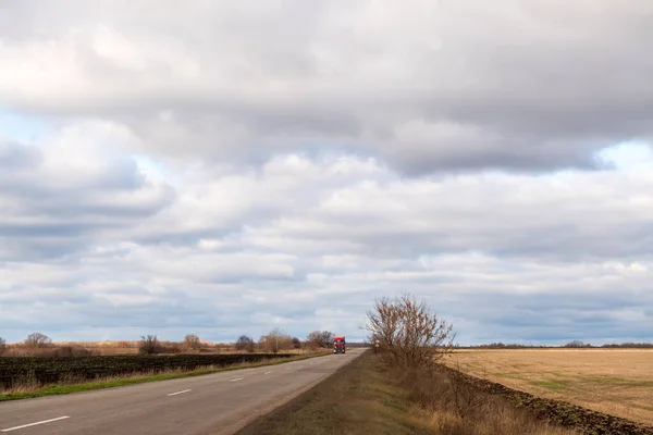 Autumn rural landscape with a truck driving along the road