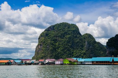 Çingene köyünün deniz manzarası dağların arka planına ve bulutlu gökyüzüne karşı. Adaman Denizi. Tayland.
