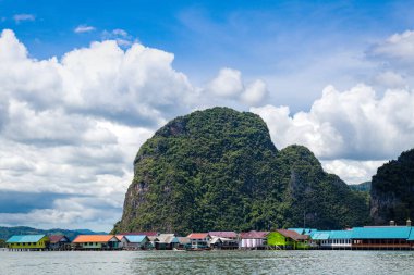 Çingene köyünün deniz manzarası dağların arka planına ve bulutlu gökyüzüne karşı. Adaman Denizi. Tayland.