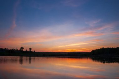Gölün sakin sularında yansıyan güzel günbatımı..
