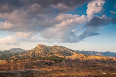 Sudak, Kırım - Cape Meganom 'un manzarası. Kırım dağlarının tepesinde, güzel bulutları olan mavi gökyüzünün arka planında..