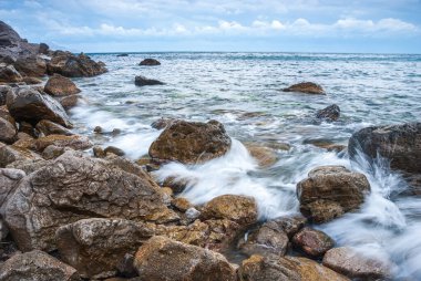 Kırım sahilinin deniz manzarası. Dalgalar kayalara karşı güzel su sıçratır..