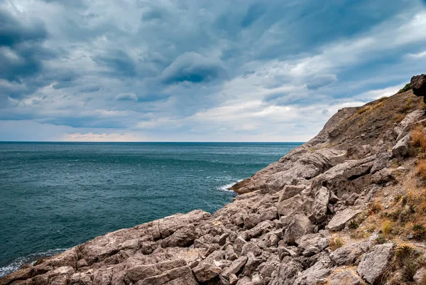 Kırım sahilinin deniz manzarası. Dalgalar kayalara karşı güzel su sıçratır..