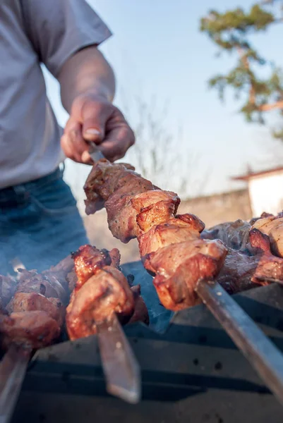 Bir adam ızgarada dumanla barbekü hazırlıyor.. 