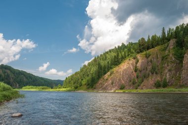 Sibirya 'nın manzarası. Kiya Nehri, dağ kıyıları ve Kemerovo bölgesindeki yeşil ormanlar. Mavi gökyüzü ve bulutlu gündüz manzarası.