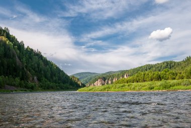 Sibirya 'nın manzarası. Kiya Nehri, dağ kıyıları ve Kemerovo bölgesindeki yeşil ormanlar. Mavi gökyüzü ve bulutlu gündüz manzarası.