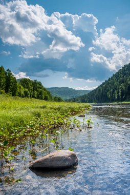 Sibirya 'nın manzarası. Kiya Nehri, dağ kıyıları ve Kemerovo bölgesindeki yeşil ormanlar. Mavi gökyüzü ve bulutlu gündüz manzarası.