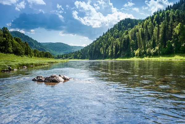 Sibirya 'nın manzarası. Kiya Nehri, dağ kıyıları ve Kemerovo bölgesindeki yeşil ormanlar. Mavi gökyüzü ve bulutlu gündüz manzarası.
