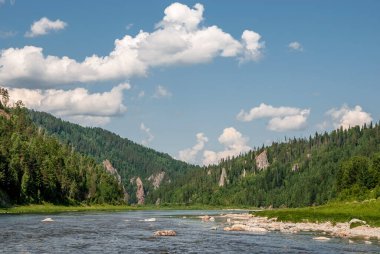 Sibirya 'nın manzarası. Kiya Nehri, dağ kıyıları ve Kemerovo bölgesindeki yeşil ormanlar. Mavi gökyüzü ve bulutlu gündüz manzarası.