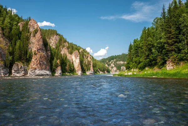 Sibirya 'nın manzarası. Kiya Nehri, dağ kıyıları ve Kemerovo bölgesindeki yeşil ormanlar. Mavi gökyüzü ve bulutlu gündüz manzarası.
